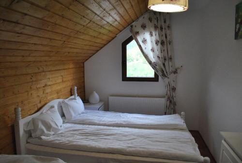 a bedroom with a white bed in a attic at Casa Magnolia in Bran