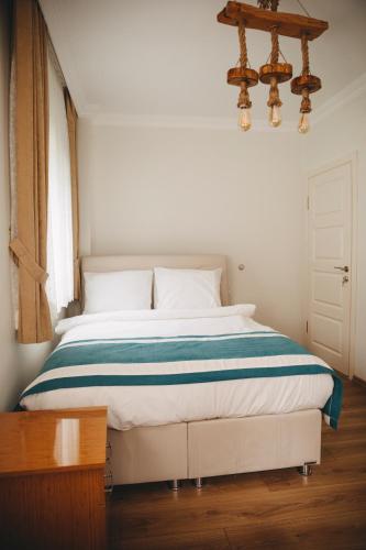 a bedroom with a bed with a blue and white blanket at Ayder Palas Apart Hotel in Ayder Yaylasi