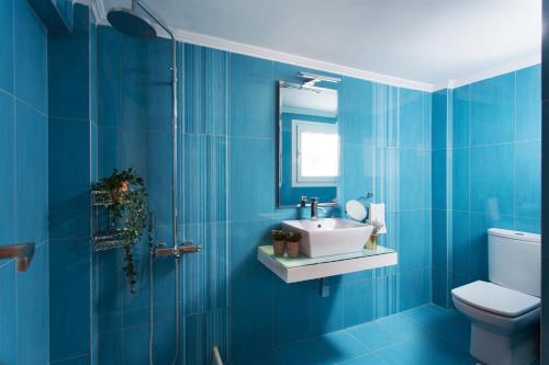 a blue bathroom with a sink and a toilet at Aneli Luxury Villas-Villa Aegina in Aegina Town