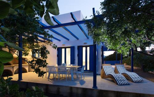 a patio with a table and chairs on it at Aneli Luxury Villas-Villa Aegina in Aegina Town