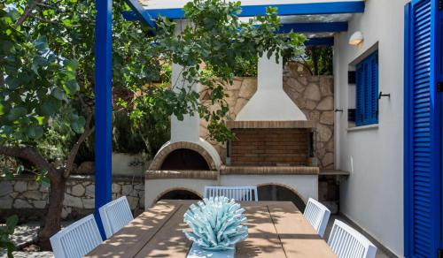 a patio with a table and a fireplace at Aneli Luxury Villas-Villa Aegina in Aegina Town