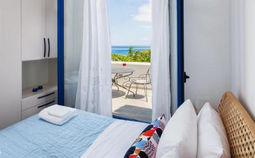 a bedroom with a bed and a view of the ocean at Aneli Luxury Villas-Villa Aegina in Aegina Town