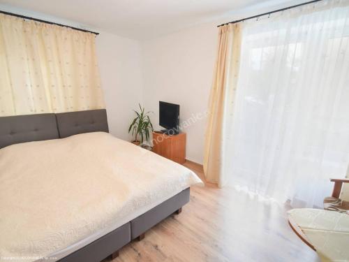 a bedroom with a bed and a large window at Kacperek in Jastarnia