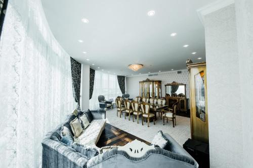 a living room with a couch and a dining room at Hotel Arai Plaza in Taraz