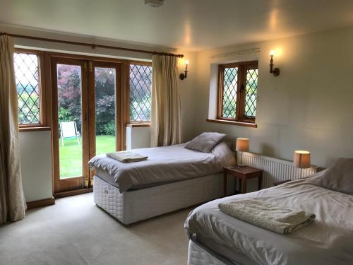 a bedroom with two beds and a window at Hurst Hill in Dunsfold