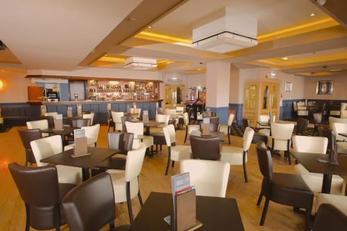 a restaurant with tables and chairs and a bar at Tiffany's Hotel in Blackpool