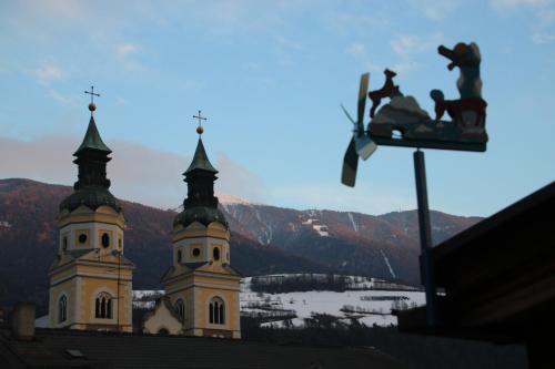 a church with two towers with two people riding on a traffic light at ADAM Suites - Brixen Card included in Bressanone