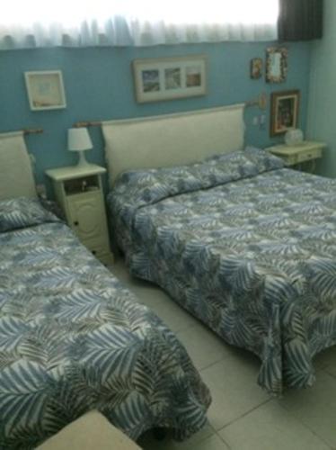 Duas camas num quarto com paredes azuis em Marina Di Bibbona em Marina di Bibbona