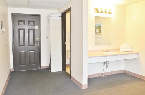W łazience znajduje się umywalka i lustro. w obiekcie Otter Creek Inn w mieście Alexandria Bay