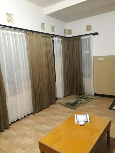 a living room with curtains and a table at The New Orlinds Guest House in Wonosari