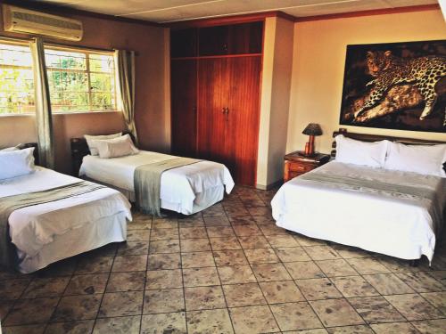 a hotel room with two beds and a television at Safari Travelodge in Kuruman