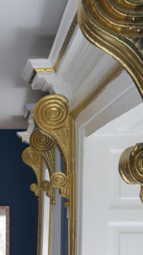 a gold mirror on a door in a room at Abbey View House in Youghal