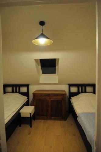 ウルガットにある38 La Cour du Moulinのベッドルーム1室(ベッド2台、照明、窓付)
