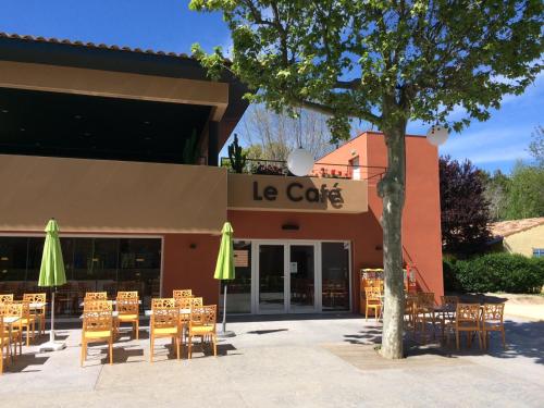 a restaurant with tables and chairs in front of a building at Camping Le Méditerranée Argelès - Domaine piétonnier in Argelès-sur-Mer