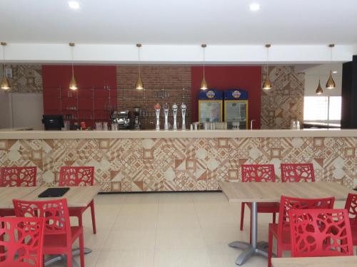 a restaurant with tables and red chairs and a counter at Camping Le Méditerranée Argelès - Domaine piétonnier in Argelès-sur-Mer