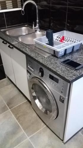 a washing machine in a kitchen with a sink at Executive 2 bed Apartment, free WIFI and DSTV in Johannesburg