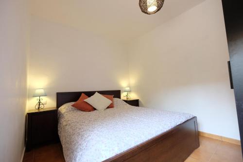 a bedroom with a bed with two lamps on it at TURISMe RURAL EMPORDA in Torroella de Montgrí