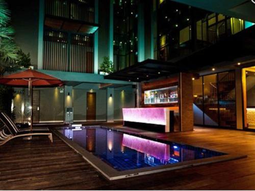 曼谷的住宿－暹羅思瓦納酒店，一座带遮阳伞的建筑中央游泳池