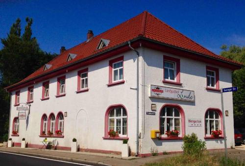 Landgasthof Linde Hepbach, Hotel & Restaurant في ماركدورف: مبنى ابيض بسقف احمر على شارع