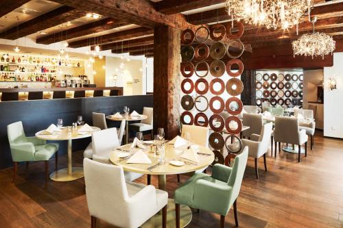 a restaurant with tables and chairs and wine barrels at Hotel Uzwil in Uzwil