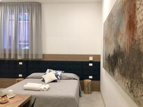 Al Pozzo di Luce Venezia Suites في البندقية: غرفة نوم بسريرين ولوحة على الحائط