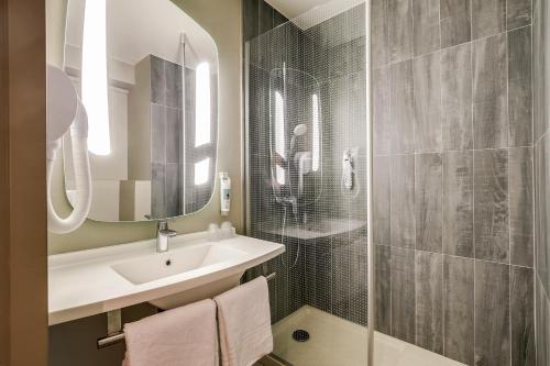 a bathroom with a sink and a shower at Ibis Marne la Vallée Noisy in Noisy-le-Grand
