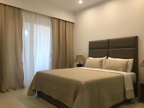 ein Schlafzimmer mit großem Bett und Fenster in der Unterkunft Golden View Residence in Dhërmi