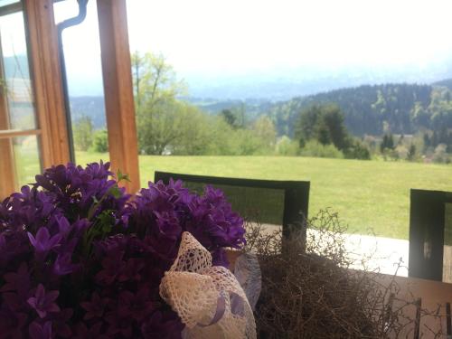a bunch of purple flowers sitting on a table next to a window at Der Weber - Haus der Zukunft in Hermagor
