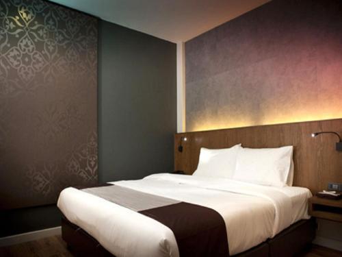 曼谷的住宿－暹羅思瓦納酒店，一间卧室配有一张带白色床单的大床