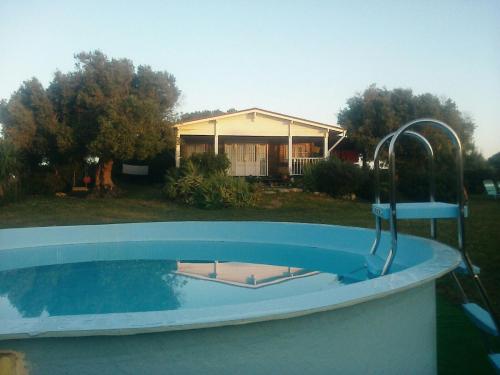 una piscina con rubinetto di fronte a una casa di Casa Rural La Zarzamora a Vejer de la Frontera