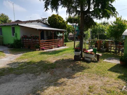 una casa con un albero e fiori nel cortile di Bungalow Gambaro a Cavallino-Treporti