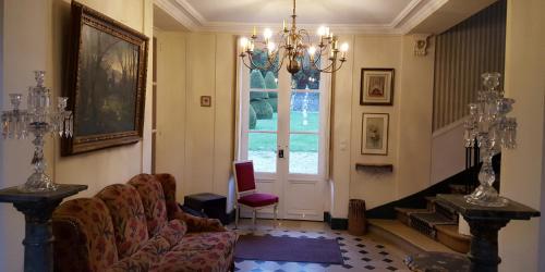 a living room with a couch and a chandelier at Château Rouillon d'Allest in Chartrettes