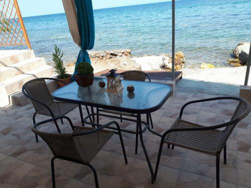 a table and chairs with a view of the ocean at Bluetopia studio in Skala Kallirachis