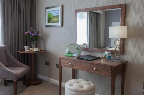 a hotel room with a desk and a mirror at Four Seasons Hotel & Leisure Club in Monaghan