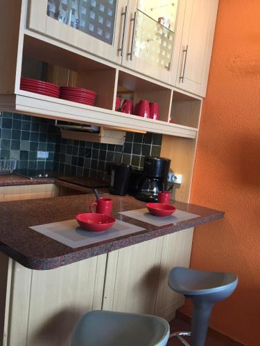 une cuisine avec 2 bols rouges sur un comptoir dans l'établissement Studio au pied des pistes et funiculaire, à Tignes