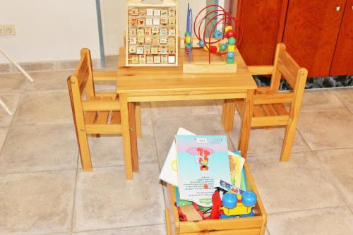 a wooden table with two chairs and a toy house at Hotel Alsterquelle in Henstedt-Ulzburg
