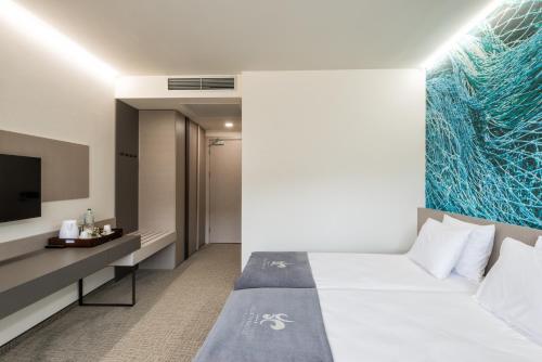 een hotelkamer met een bed en een tv bij Aqua Paradise Resort & Aqua Park in Nesebar