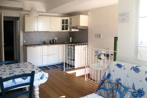 - une cuisine avec des placards blancs et une table dans une pièce dans l'établissement Appartamento mare Sirolo con garage privato, à Sirolo