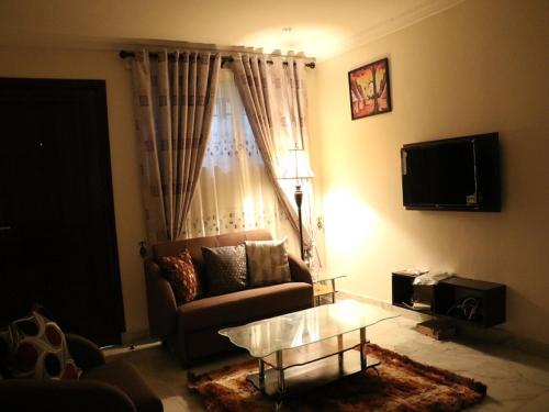 a living room with a couch and a coffee table at Jaria Apartments in Accra