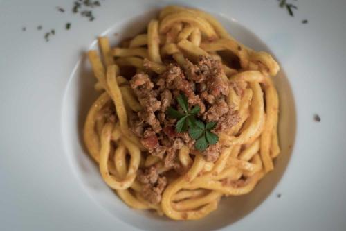a bowl of spaghetti with meat on a plate at Il Feudo in Vo Euganeo