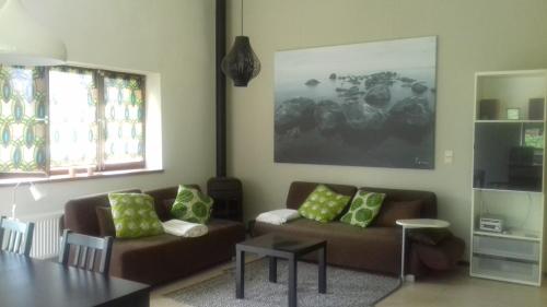 a living room with two couches and a table at Gîte de Thirifays in Chiny
