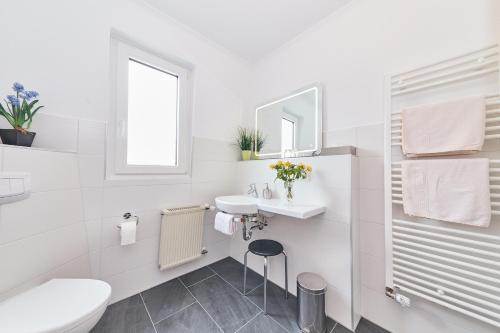 a white bathroom with a sink and a toilet at Ferienwohnung "Edeltrud Deluxe Moselblick" in Bernkastel-Kues