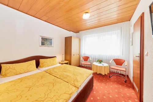 ベルンカステル・クースにあるFerienwohnung "Edeltrud Deluxe Moselblick"のベッドルーム1室(ベッド1台、椅子2脚、窓付)