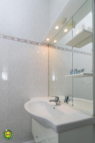 une salle de bain blanche avec un lavabo et un miroir dans l'établissement La Pastorale, à Moirans