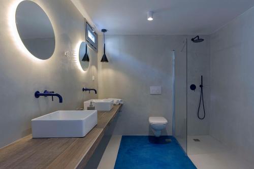 a bathroom with a sink and a toilet and a mirror at Sealine Villas in Tourlos