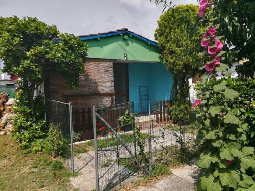 a blue house with a fence in front of it at Bungalow Gambaro 2 in Cavallino-Treporti