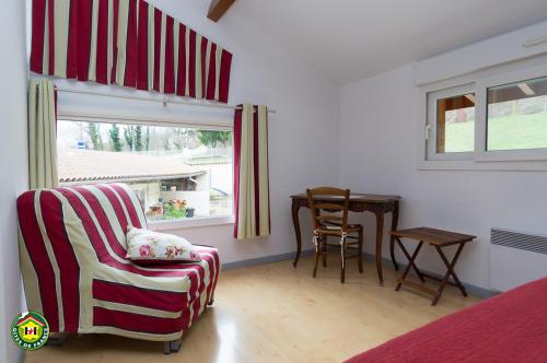 Habitación con silla, mesa y ventana en La Pastorale, en Moirans