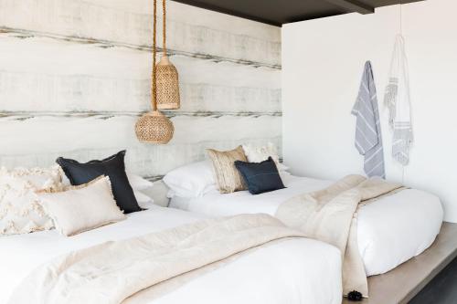 two beds in a room with white walls at AWOL Hotel Provincetown in Provincetown