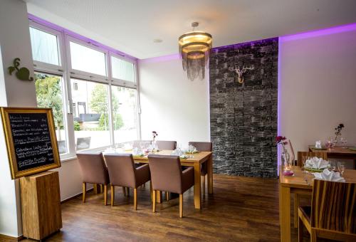 a dining room with a table and chairs and purple lighting at Caravelle Hotel im Park in Bad Kreuznach