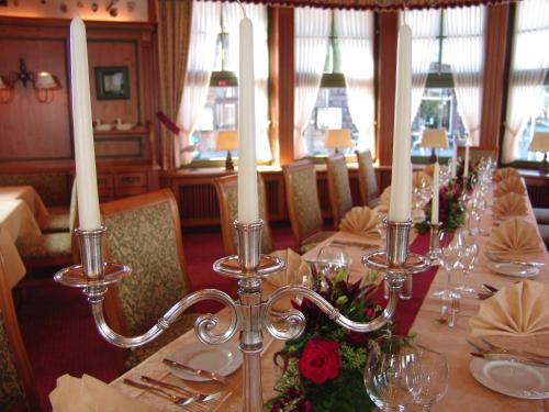 uma sala de jantar com uma mesa longa com velas brancas em Hotel Coellner Hof em Colônia